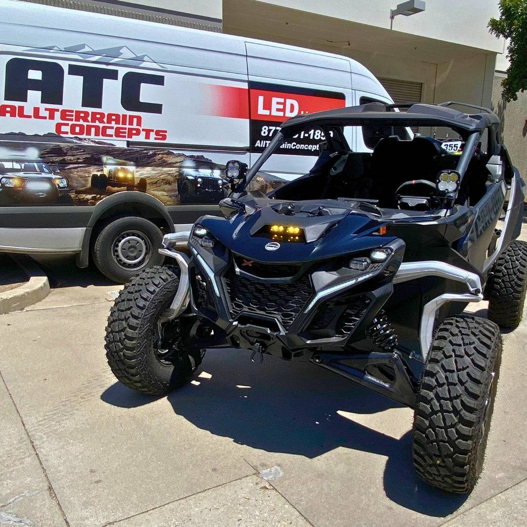 Can-Am Maverick R with ATC Maverick R Hood Kit LED pods installed showing mounting under the hood with branded All Terrain Concepts van in background