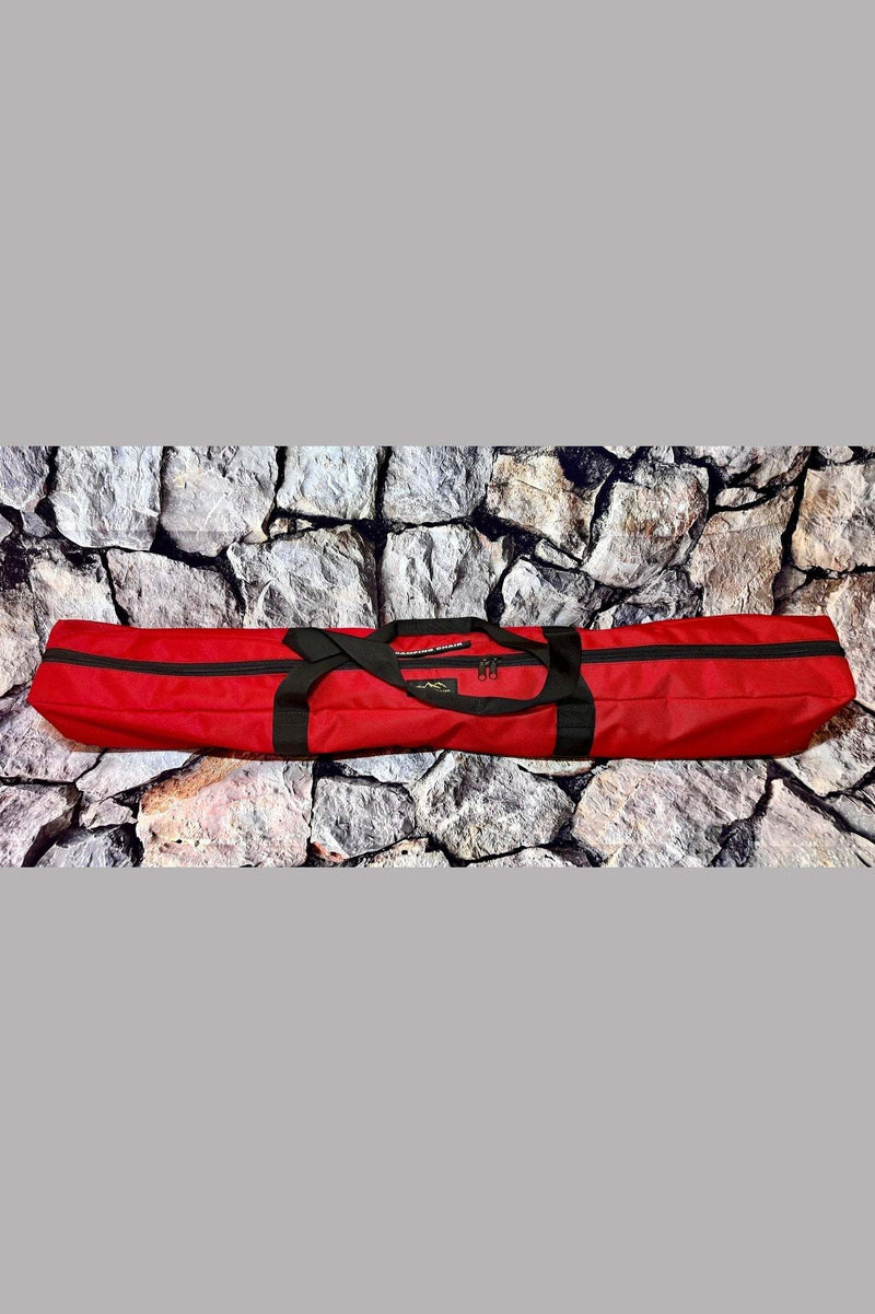 Red convenient easy to carry camping chair bag with full-length zipper and wraparound handles on stone background