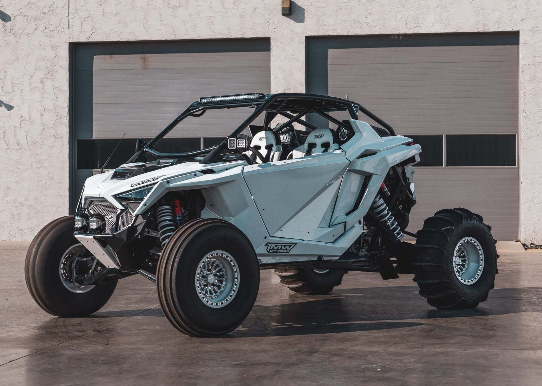 TMW GEN 2 RZR PRO R two-seat doors installed on white Polaris RZR off-road vehicle with black tubular frame and large tires parked outdoors