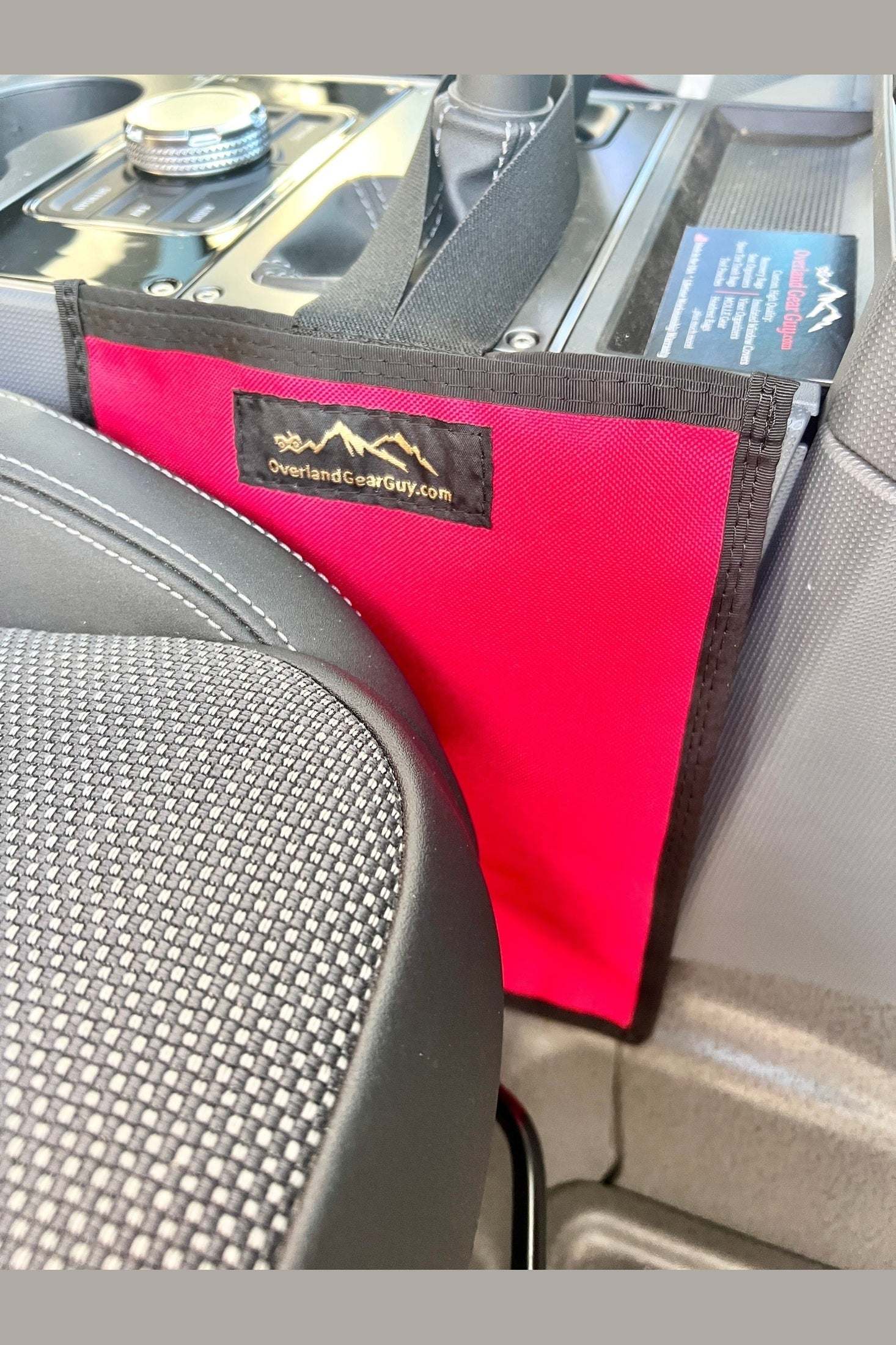Grenadier Interior Trash Bag attached to vehicle center console, red durable material.