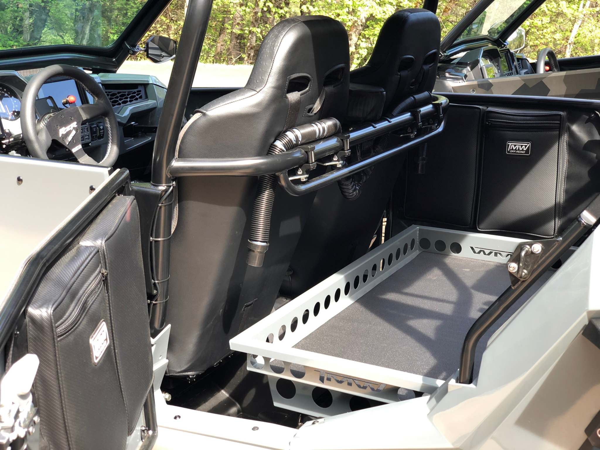 RZR rear seat delete tray installed in off-road vehicle with black seats and open cargo area tray