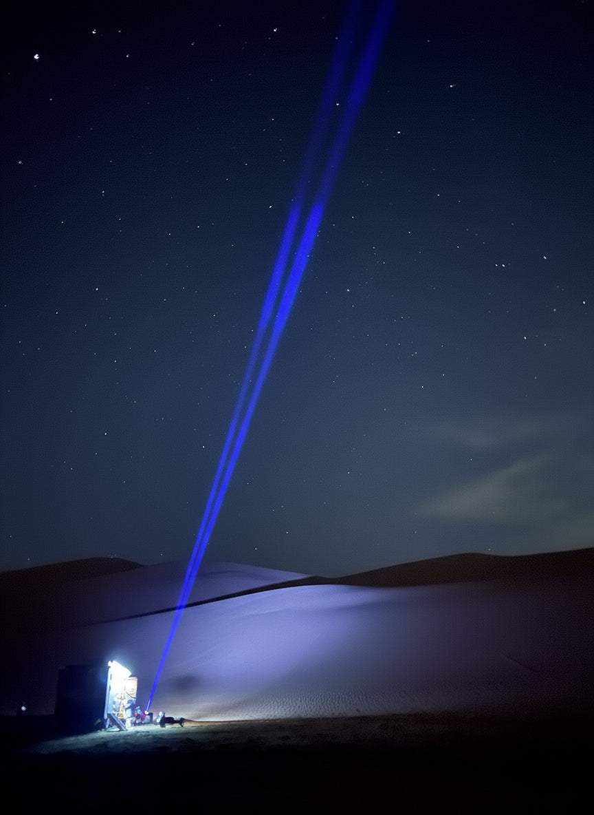 RGB Lunar Laser Whips Kit projecting bright blue laser beams into the night sky over desert dunes