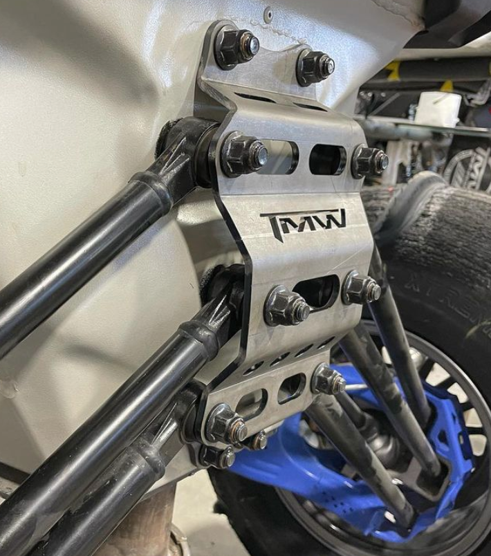 TMW 2022-2025 X3 Rear Radius Rod gusset plate installed on vehicle frame with powder coat finish and bolts.