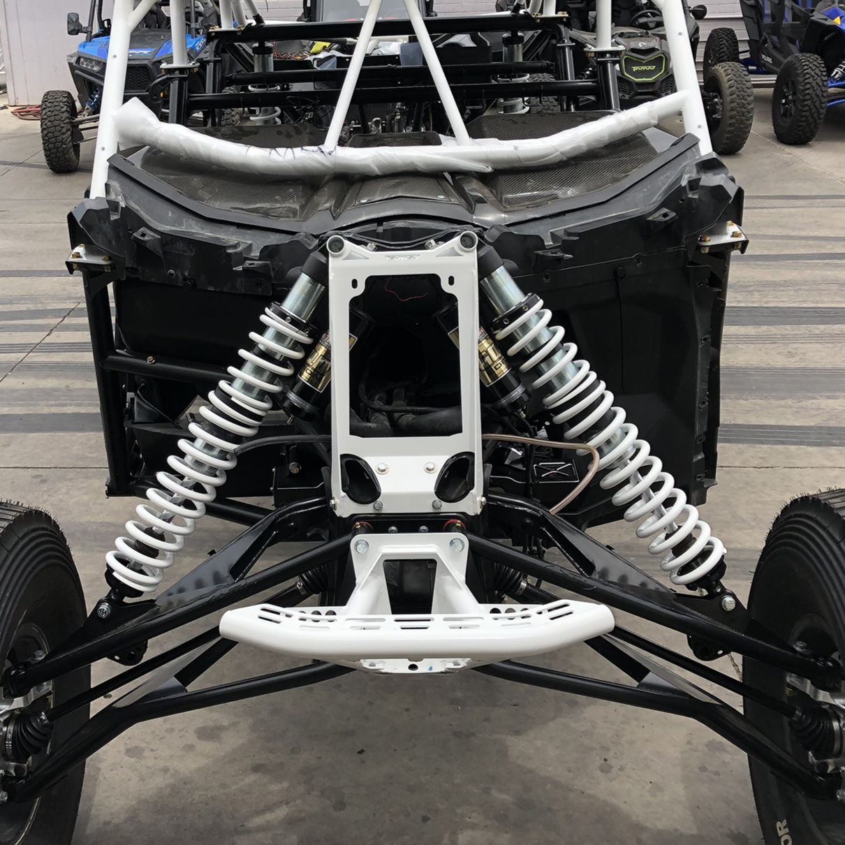Front view of CanAm X3 with installed white X3 Pro Series Shock Tower Support and dual shocks providing enhanced front shock stability